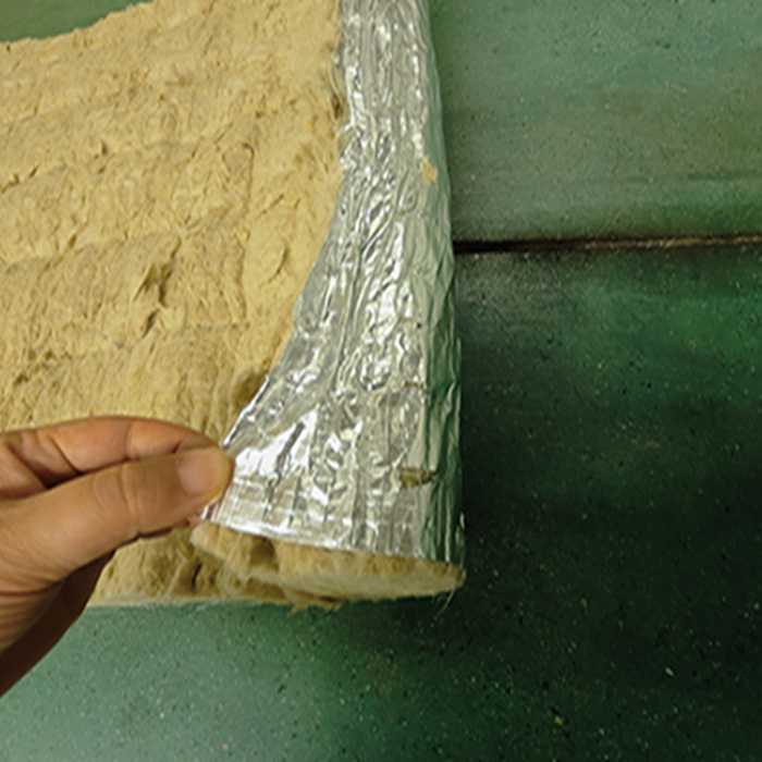Hands unrolling foil-backed insulation